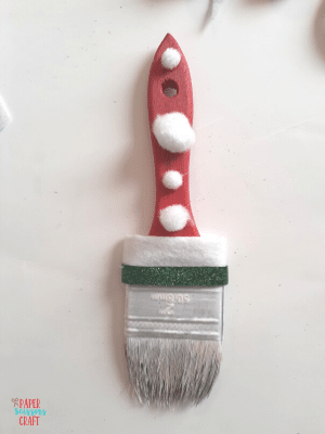 Paintbrush with white pom poms glued to its handle.