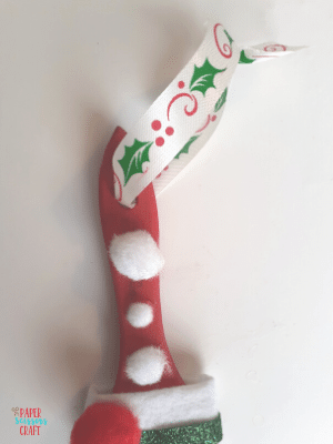 Christmas ribbon tied around the handle of a paintbrush.