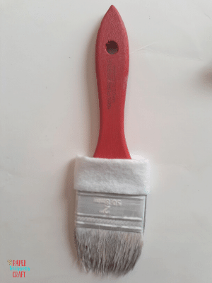 Paintbrush with a strip of white felt glued to it for a Santa Claus paintbrush ornament.