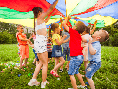 Kids playing under a parachute.