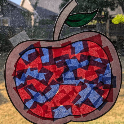 Apple suncatcher craft hanging on a window.