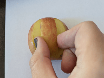 Apple stamp being pressed onto paper.