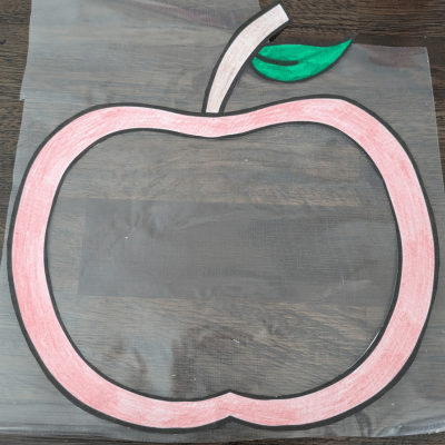 Apple template after being cut out and colored in on top of contact paper.