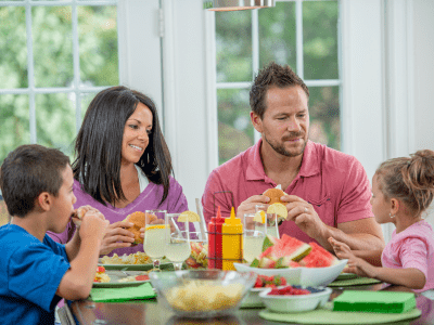 Family of four eating a meal at the kitchen table.