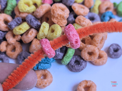 Red Froot Loops threaded onto a red pipe cleaner.